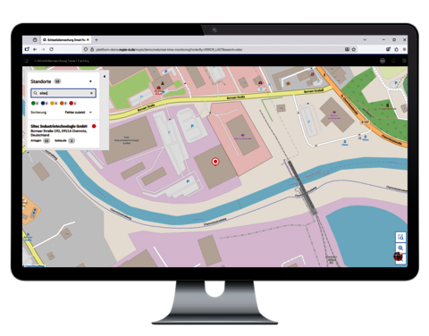 Monitor mit Kartenansicht eines Werksstandorts in der Echtzeitüberwachung, inklusive Standortdetails in der Seitenleiste.