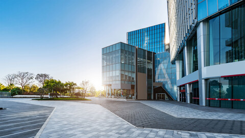 Moderner Bürokomplex mit Glasfassade und Vorplatz, stellvertretend für professionelles Facility Management und digitale CAFM-Lösungen für Gebäudebetreiber.